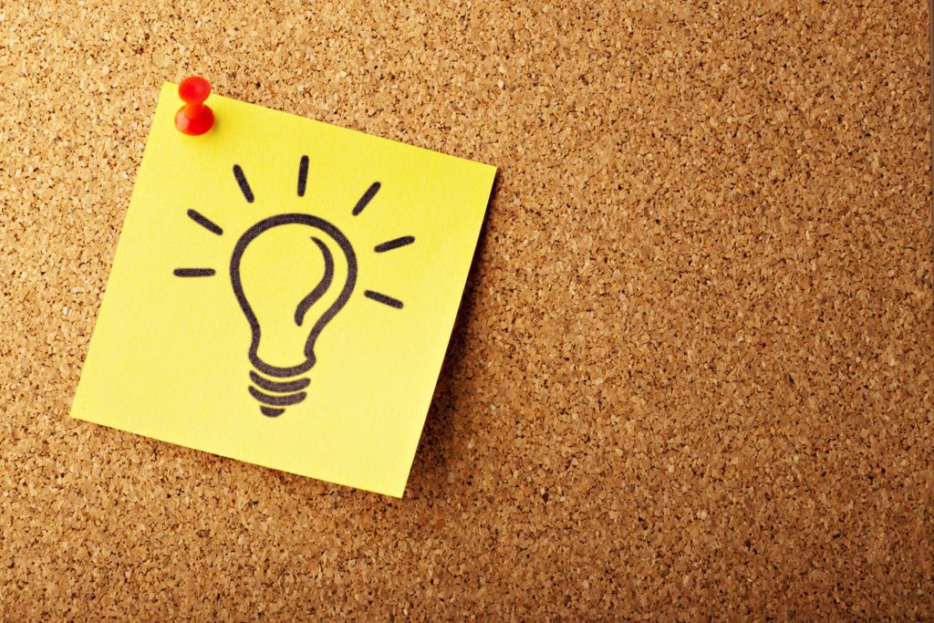 image of a light bulb on a sticky note pinned to a cork board